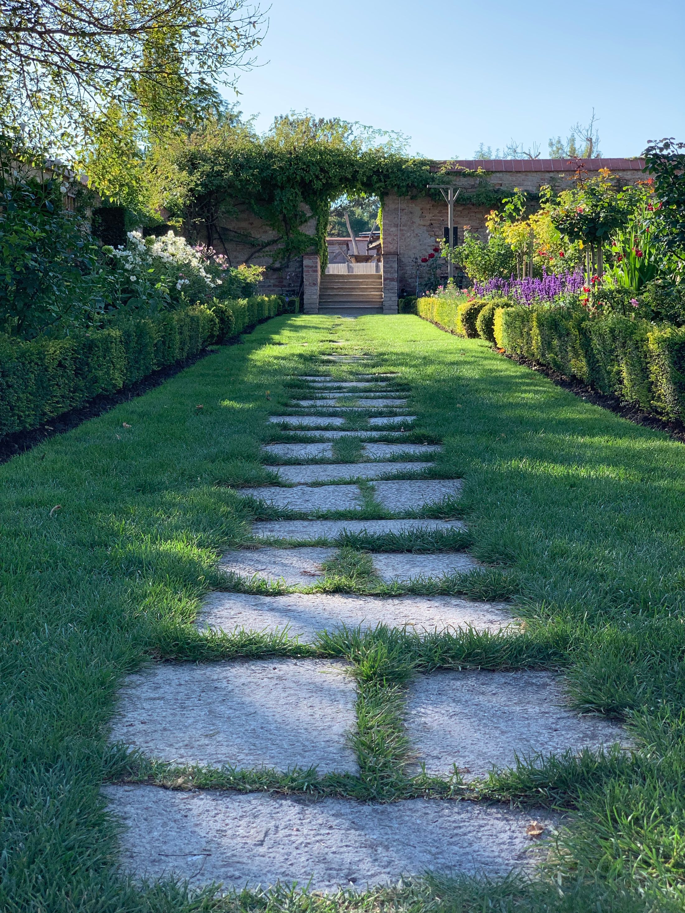 Gepflegter Garten mit Weg und üppiger Bepflanzung