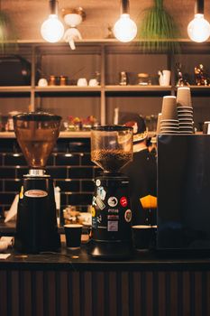 Warm coffee shop scene featuring espresso machines and ambient lighting at a stylish counter.