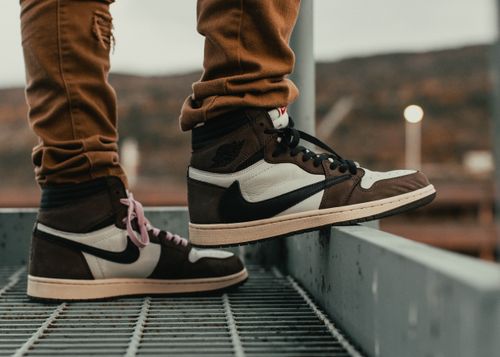 Free Stylish high-top sneakers paired with casual pants in an outdoor urban setting. Stock Photo
