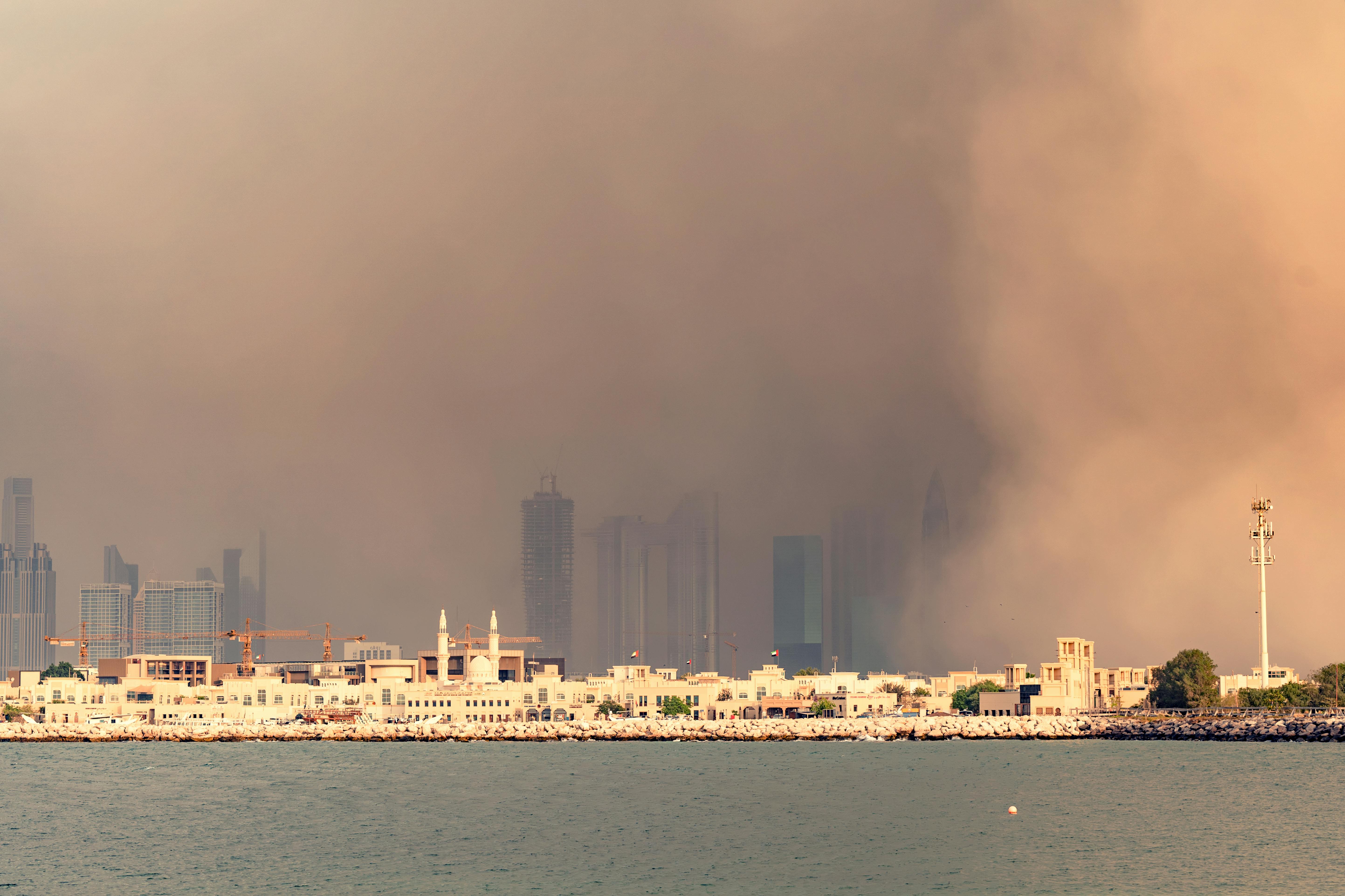 A dense sandstorm envelops Dubai's iconic skyline, creating a striking urban scene.