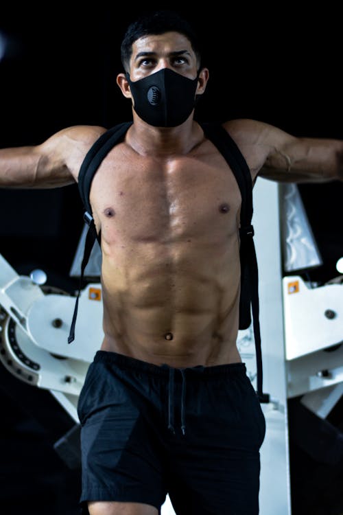 A Man Exercising in a Gym Wearing a Face Mask