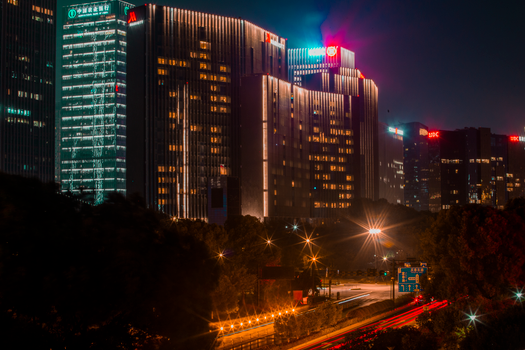 Explore the bright skyline of Hangzhou, China, with its illuminated skyscrapers and bustling highways at night.