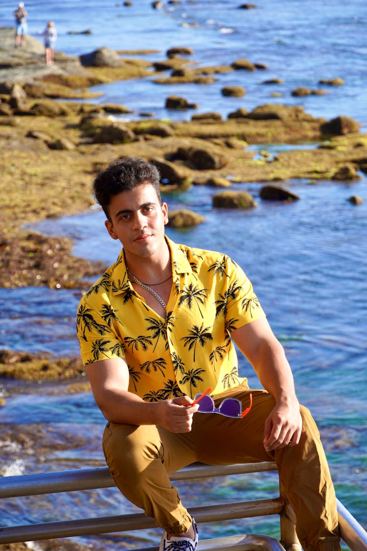 A Man In The Beach Wearing Hawaiian Polo