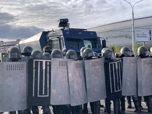Free A Group of Soldiers Lined Up with Shields in Front of an Armored Van Stock Photo