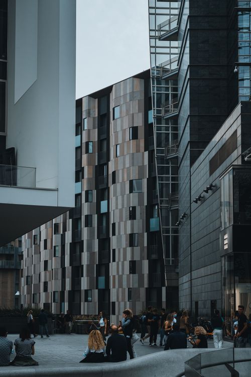 Free A bustling urban scene featuring contemporary buildings and people engaging in a public space. Stock Photo