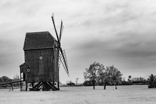 Free Grayscale Photo of a Windmill Under a Cloudy Sky Stock Photo