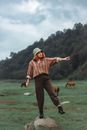Man in Red and White Plaid Dress Shirt and Brown Pants Standing on Green Grass Field
