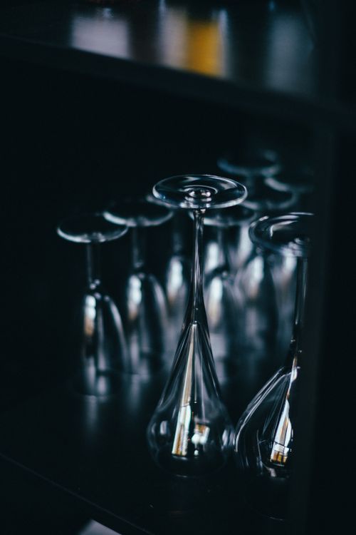Free A refined composition of upside-down wine glasses in a dark, elegant setting. Stock Photo