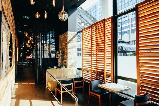 Sunlit cafe interior with contemporary design and cozy ambiance, perfect for a relaxing dining experience.