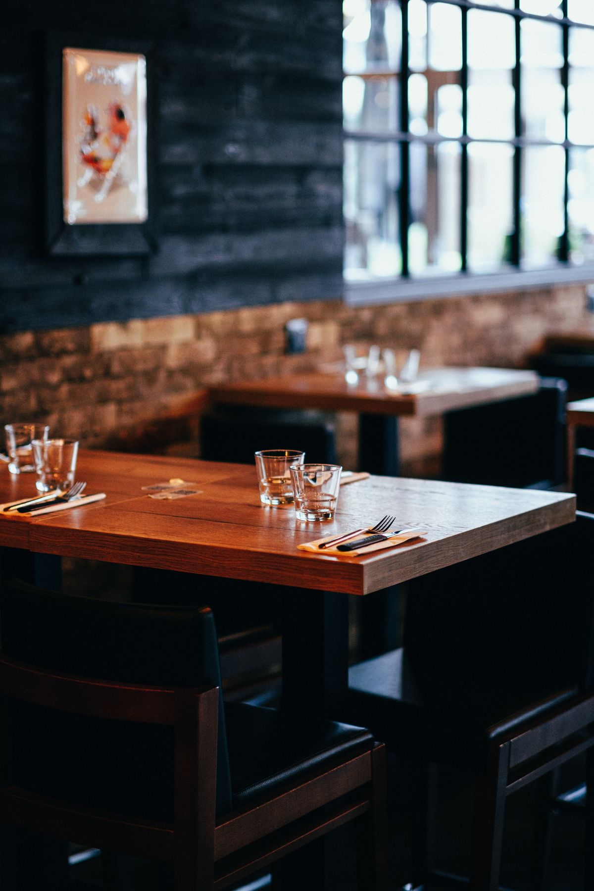 A row of drinking glasses on a wooden table, polished and completely spot-free