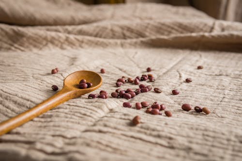 Brown Beans and Brown Wooden Spoon on Brown Textile