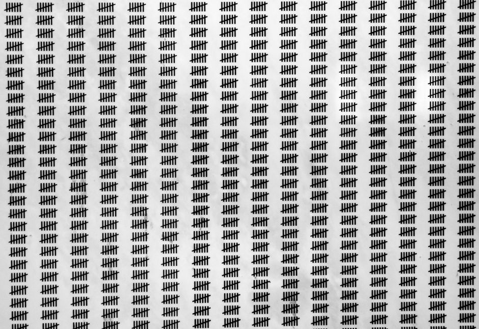 Repetitive tally mark pattern creating a visual texture on a white background.