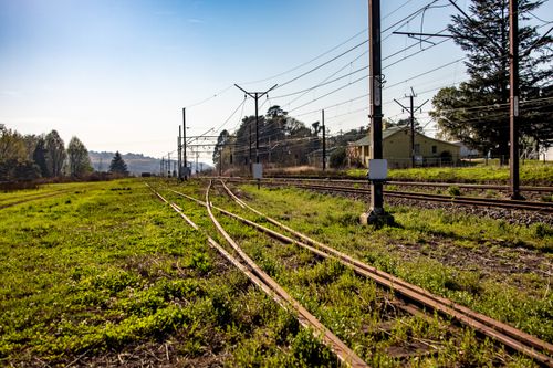Free Railway tracks stretching through the countryside under a clear blue sky. Stock Photo