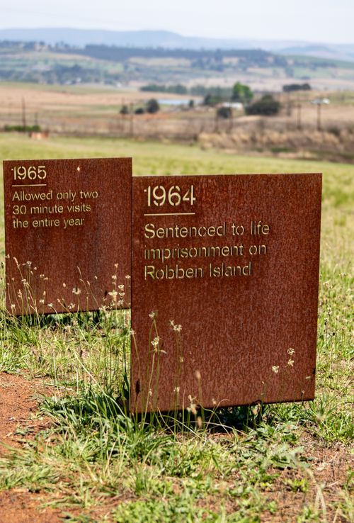 Free Memorial plaques at Robben Island commemorate significant historic events in a rural setting. Stock Photo
