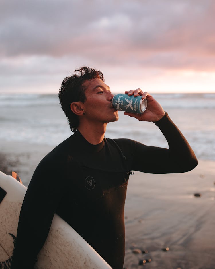 Man In Black Rash Guard Drinking From A Can