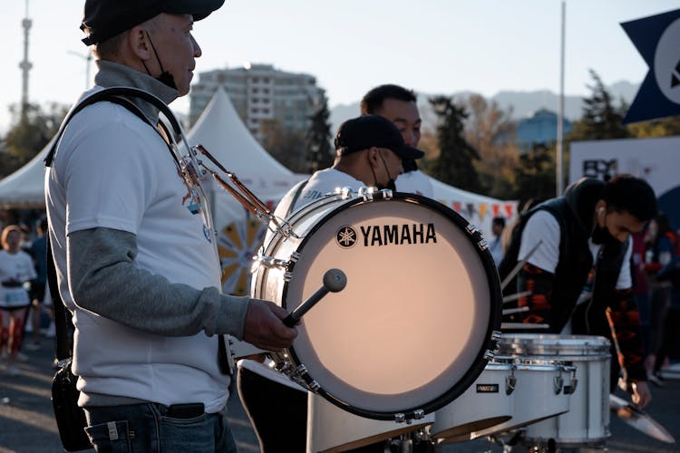 Man In White Shirt And Gray Long Sleeves Playing Drum