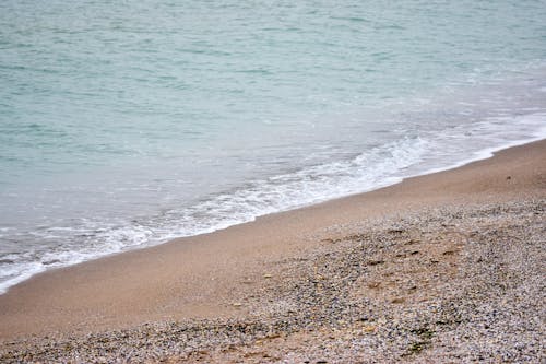 Close-Up Photo of a Beach with Sea Foam