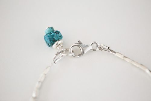 Free Detailed close-up of a silver bracelet adorned with a turquoise crystal on a white background. Stock Photo