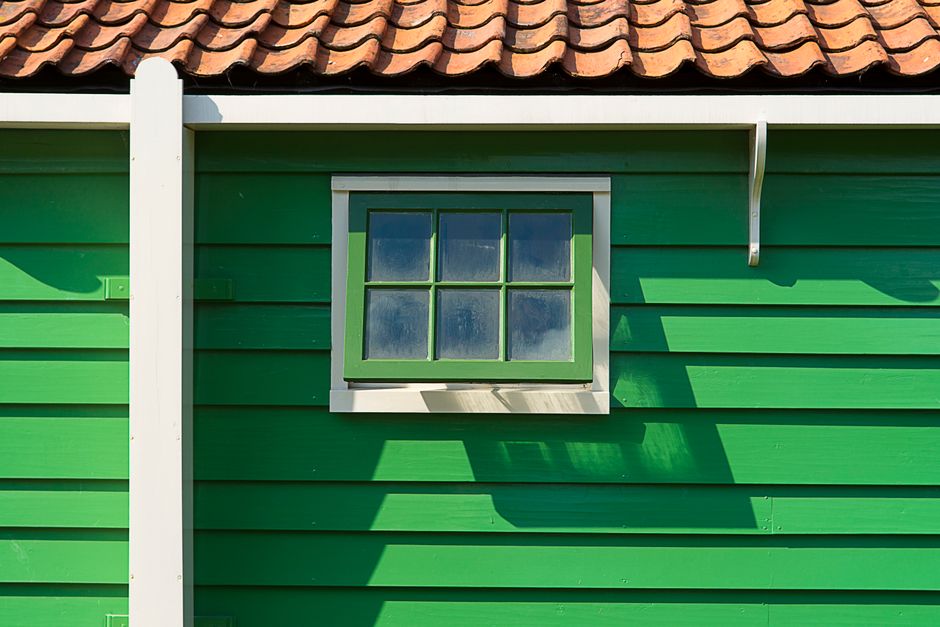 Professional painters on scaffolding painting the exterior of a large home