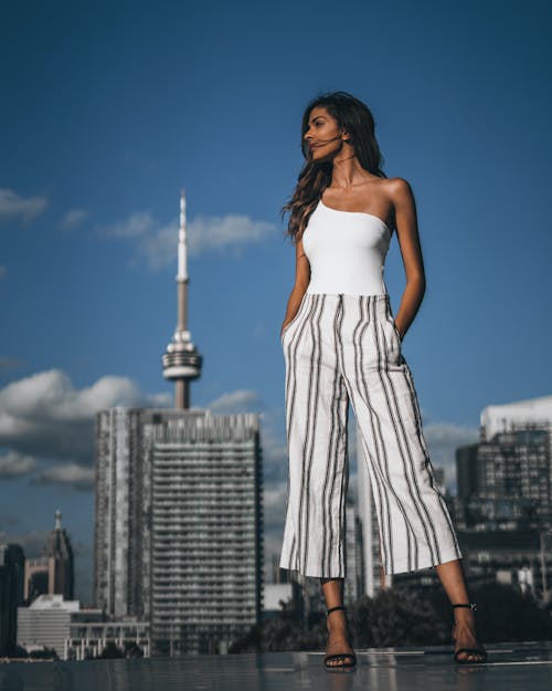 A Woman in White Top and Striped Pants Looking Over Shoulder