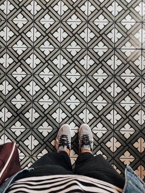Person Wearing Sneakers Standing on Tiled Floor