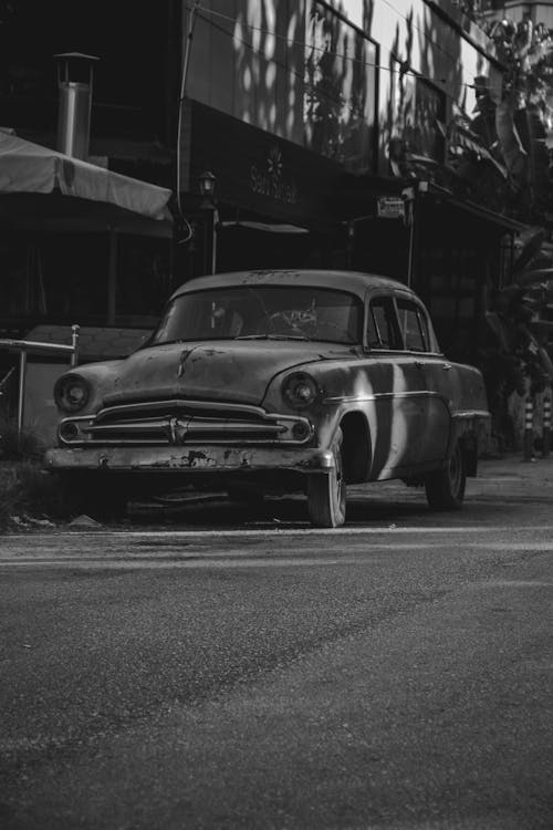 Free Grayscale Photo of a Vintage Car on the Road Stock Photo