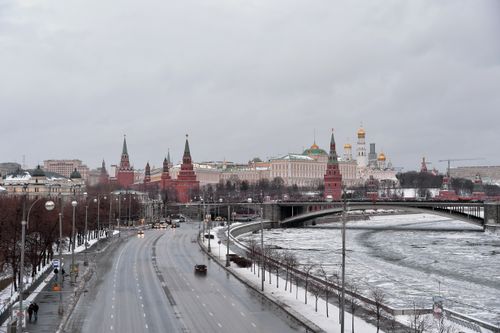 Free A scenic winter view of the Moscow Kremlin with a frozen river and empty streets under overcast skies. Stock Photo