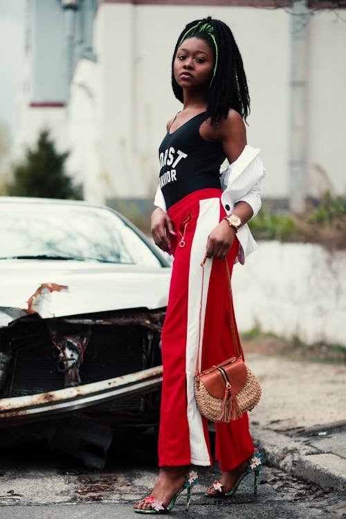 Women's Black Tank Top and Red Track Pants Walking on Street