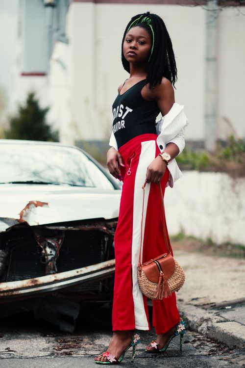Free Chic young woman in vibrant attire poses confidently in urban street setting. Stock Photo
