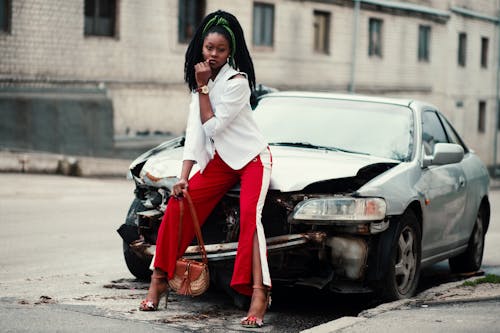 Woman Posing near the Broken Car Parked Outside