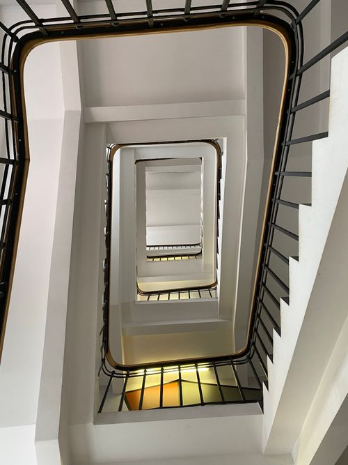 Free A low angle view of a spiral staircase with metal railings in a modern interior. Stock Photo