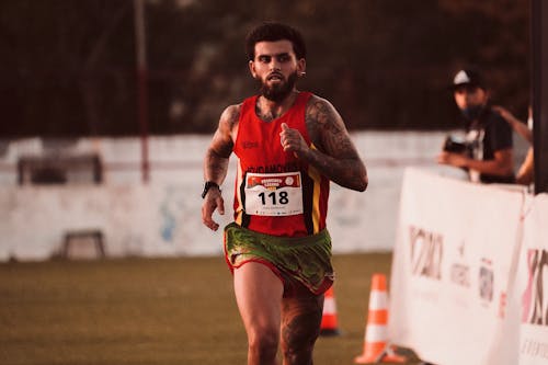 Free Man in Red Jersey Running on Field Stock Photo