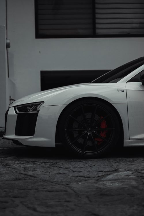 Free Luxury white sports car with black rims parked on urban pavement, exuding modern elegance. Stock Photo