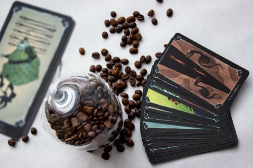 Free Top view of coffee beans in a glass and tarot cards on a white surface. A perfect blend of coffee culture and mysticism. Stock Photo
