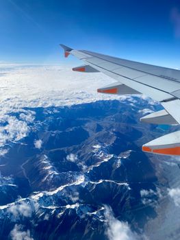 View of snow-capped mountains in New Zealand from an airplane window.