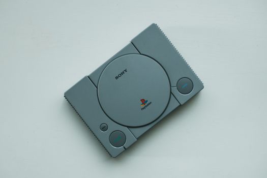 Close-up of a vintage Sony PlayStation console on a white background, highlighting retro gaming vibes.