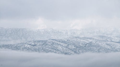 Snow Covered Mountain Under the Cloudy Sky