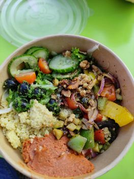 Colorful vegetarian salad with couscous, vegetables, and nuts in a ceramic bowl, perfect for healthy meals.