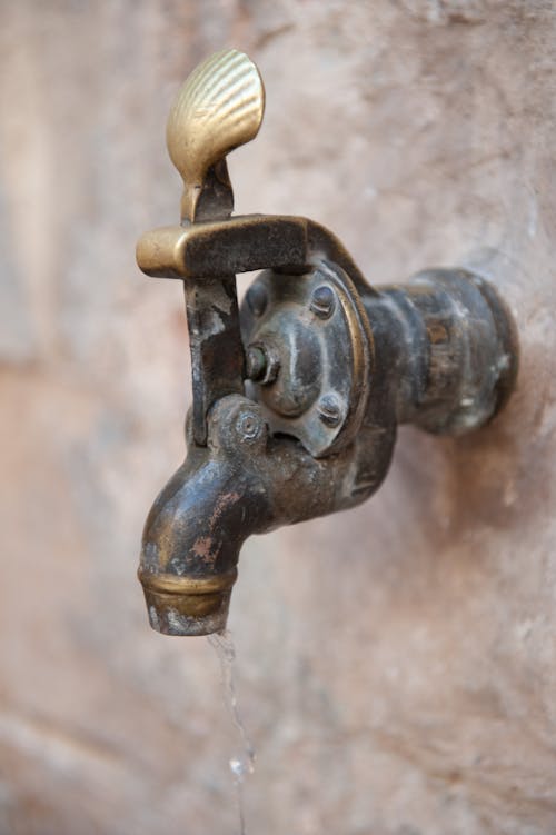 A Close-Up Shot of a Faucet with Flowing Water