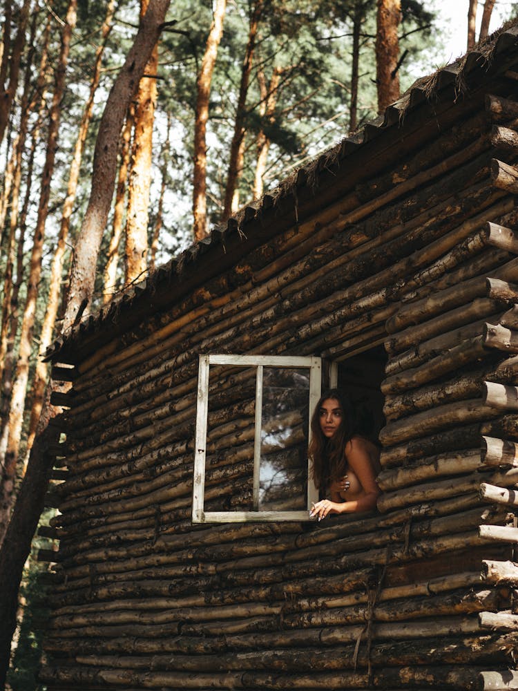 A Woman Looking At The Beautiful View Through The Window