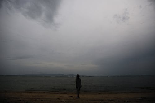 Person Standing Alone on a Gloomy Field