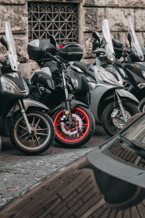 Free Street scene with multiple motorbikes parked in Naples, Italy, highlighting urban transportation. Stock Photo
