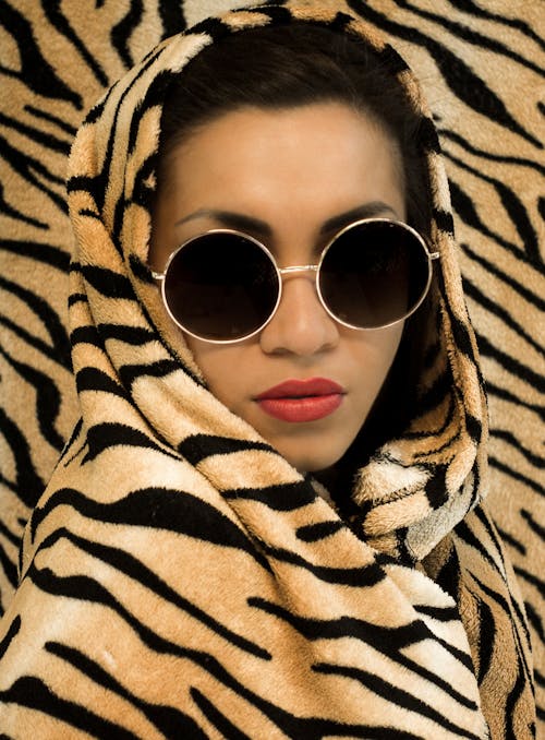 
A Woman Wearing Sunglasses and an Animal Printed Blanket