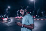 A Bearded Man Using a Smartphone on the Street