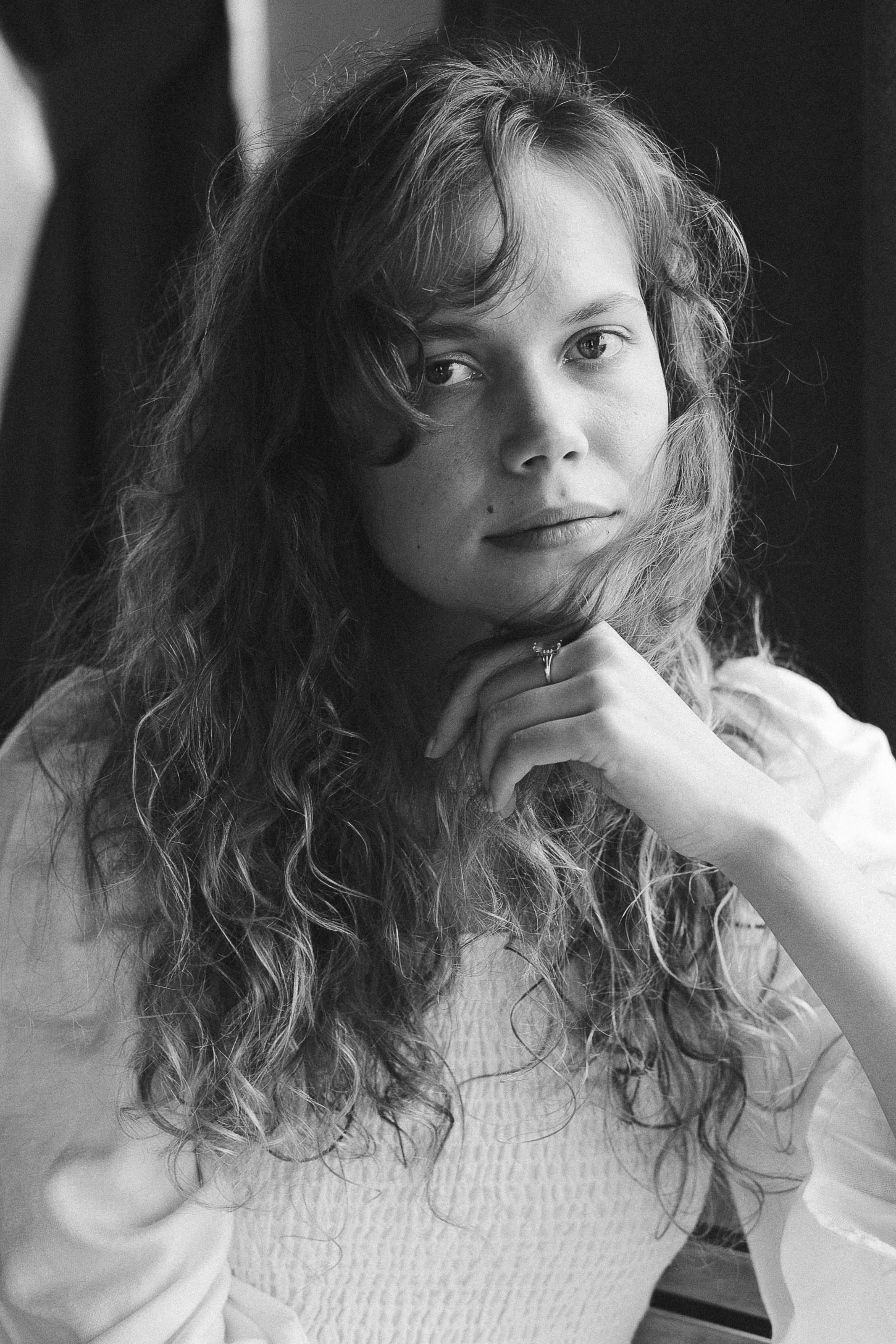 Graceful woman with curly hair in a monochrome portrait.