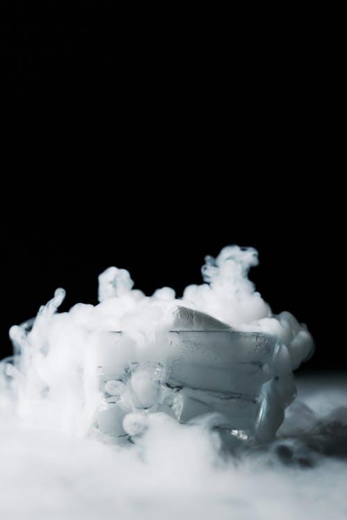 White Smoke in a Glass Container Against Black Background