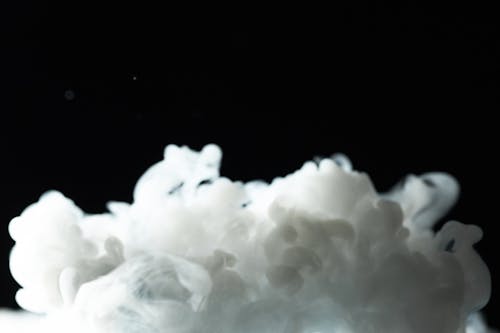 A Thick White Smoke Plume Against Black Background
