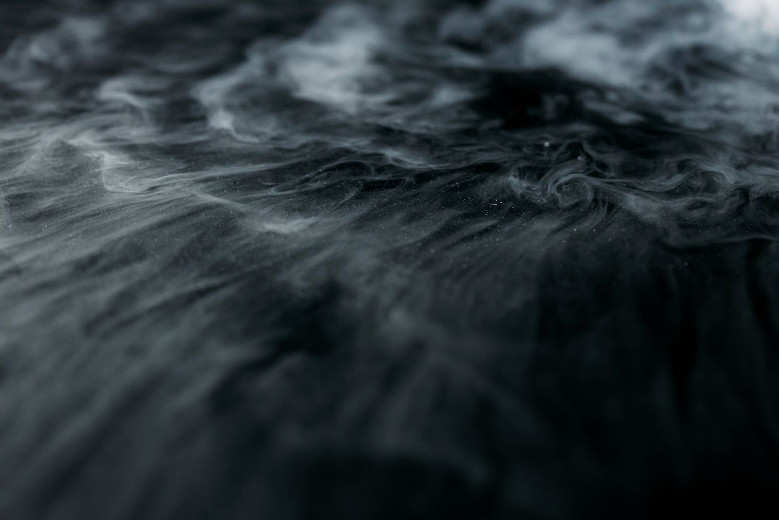 Swirling fibre dust over a dark surface — photo by cottonbro studio on Pexels