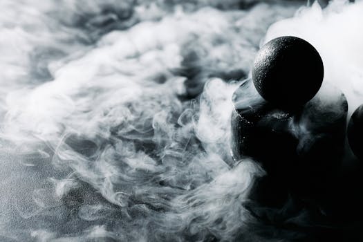 Mysterious black sphere enveloped in swirling smoke on a dark textured surface.