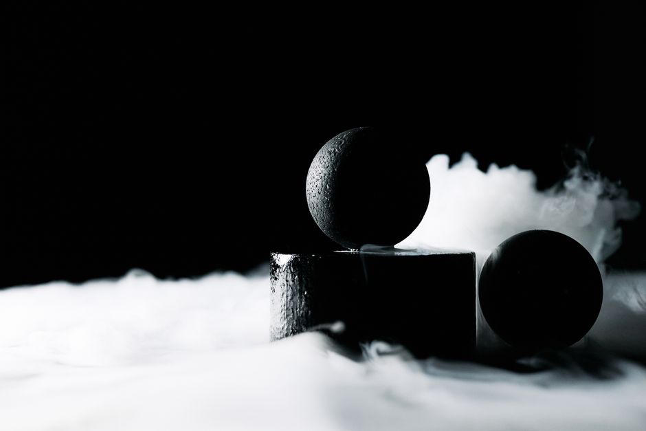 Dark abstract image featuring spheres with smoke and dramatic lighting.
